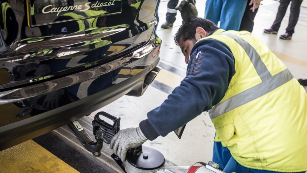 Porsche Cayenne S Diesel pulls one of Air France's 285 tonne A380 at Charles de Gaulle Airport in Paris - Techinician takes a look
